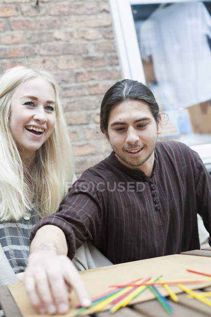 Glückliches Paar spielt Mikado — Stockfoto