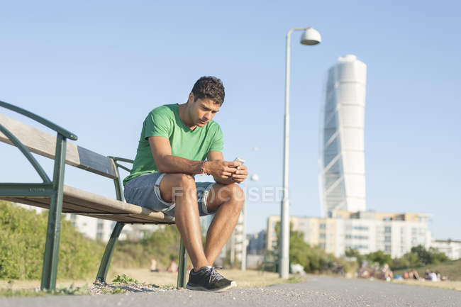 Молодий чоловік, які сидять на лавці — стокове фото