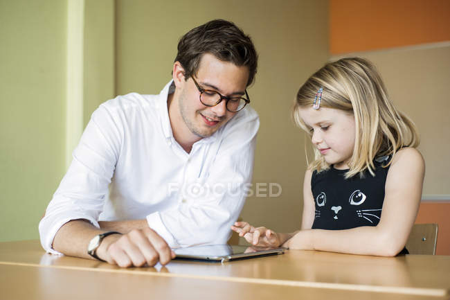Professor masculino assistindo pintura menina — Fotografia de Stock