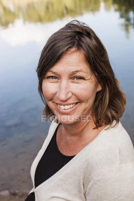 Mujer feliz en la orilla del lago - foto de stock