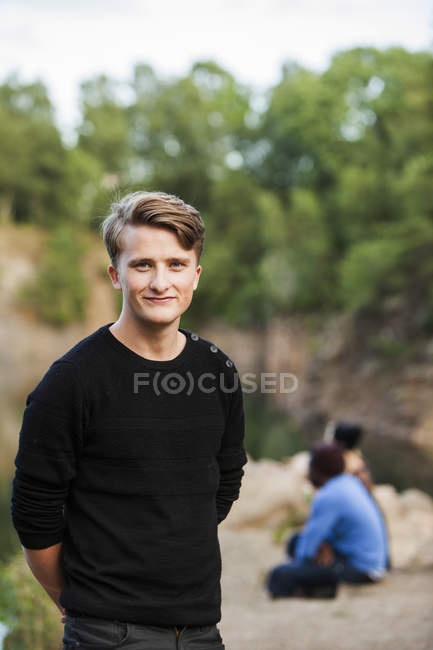 Усміхнений чоловік стоїть в лісі — стокове фото