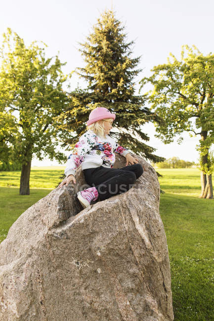 Chica sentada en la roca - foto de stock