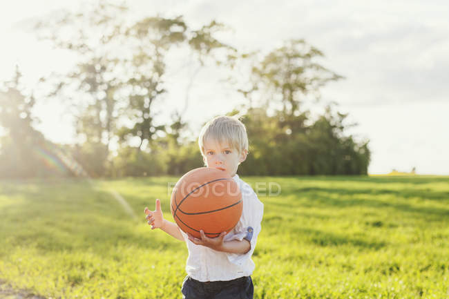 Menino bonito segurando basquete — Fotografia de Stock
