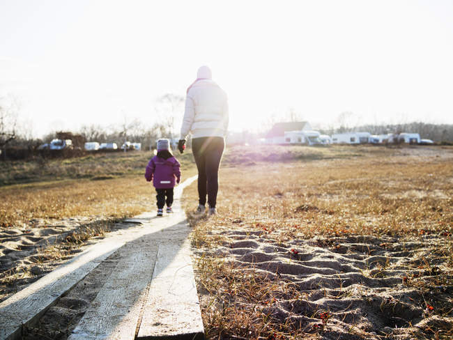 Mother with daughter walking on field — Stock Photo