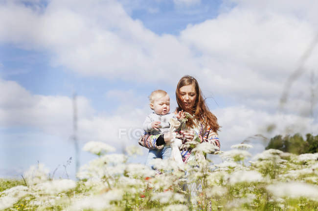 Mãe segurando filho na praia — Fotografia de Stock