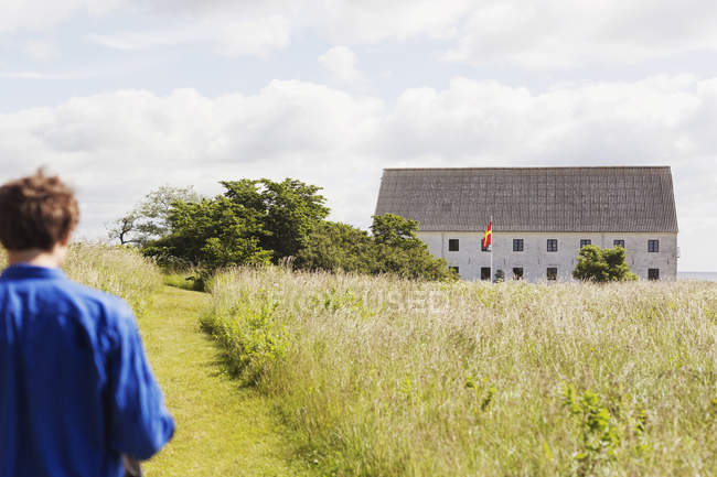 Homme marchant sur le champ herbeux — Photo de stock
