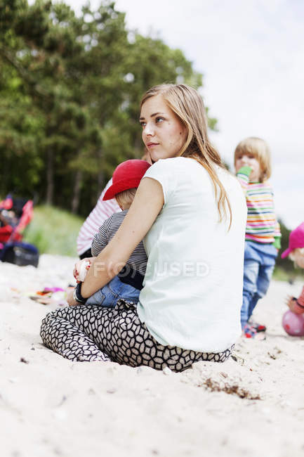 Mujer sentada con bebé niño - foto de stock