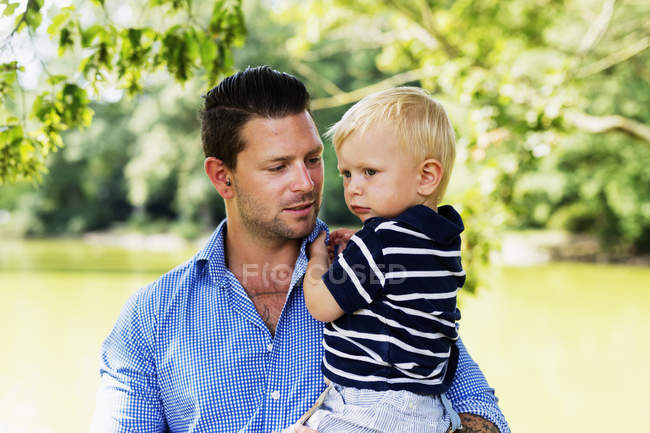 Giovane uomo che porta figlio — Foto stock