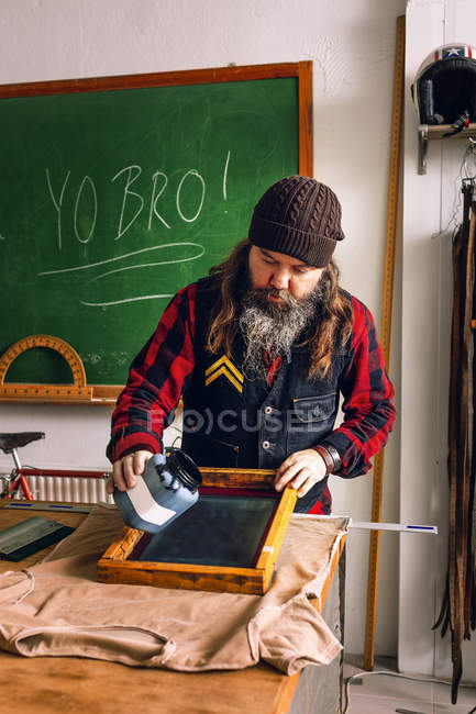 Männlicher Arbeiter gießt Tinte — Stockfoto
