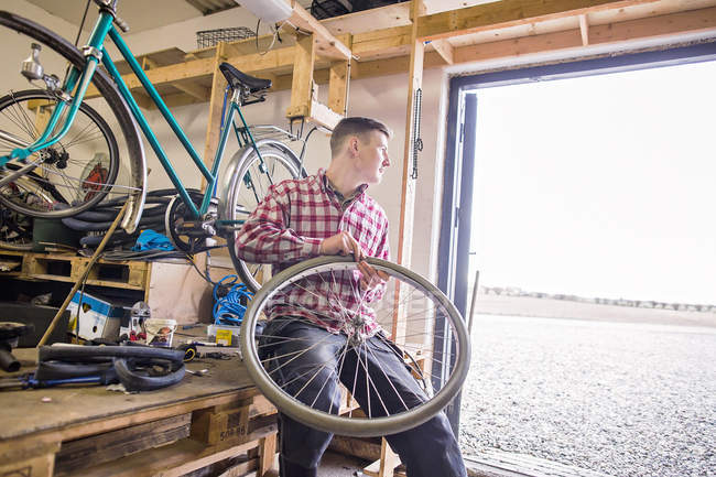Reparador sosteniendo bicicleta - foto de stock