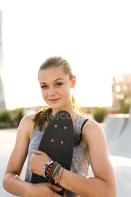 Дівчина-підліток тримає скейтборд — стокове фото