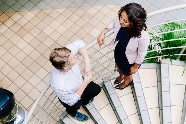 Colleagues discussing on staircase — Stock Photo