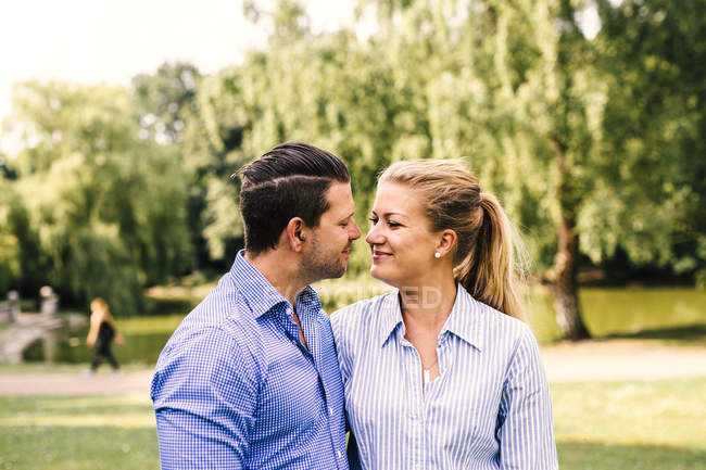 Sorridente coppia in piedi al parco — Foto stock