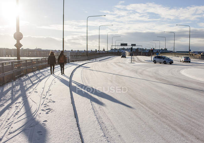 Frauen gehen auf schneebedecktem Gehweg — Stockfoto
