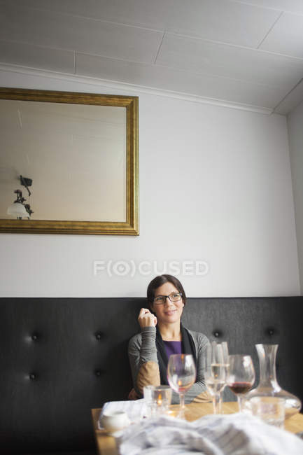Femme assise à table au restaurant — Photo de stock