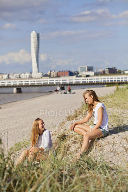 Amigos do sexo feminino conversando na praia — Fotografia de Stock