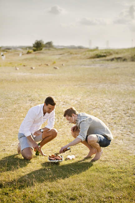 Male friends barbecuing — Stock Photo