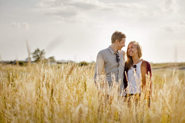 Smiling couple standing on grassy field — Stock Photo