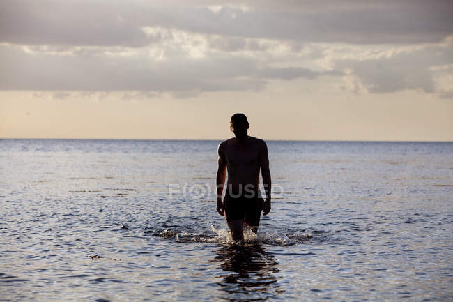 Junger Mann zu Fuß im Meer — Stockfoto