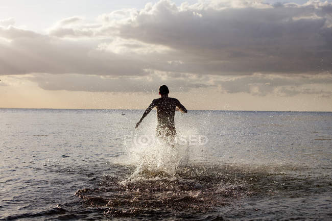 Молодий чоловік біжить у морі — стокове фото