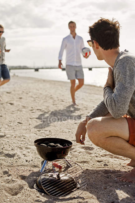Young man barbecuing — Stock Photo