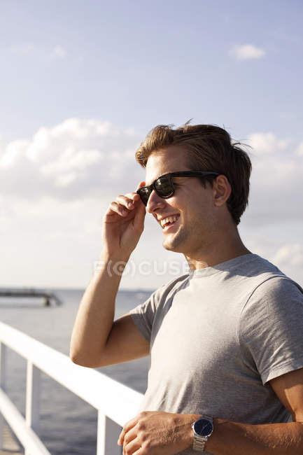 Homme portant des lunettes de soleil sur jetée — Photo de stock