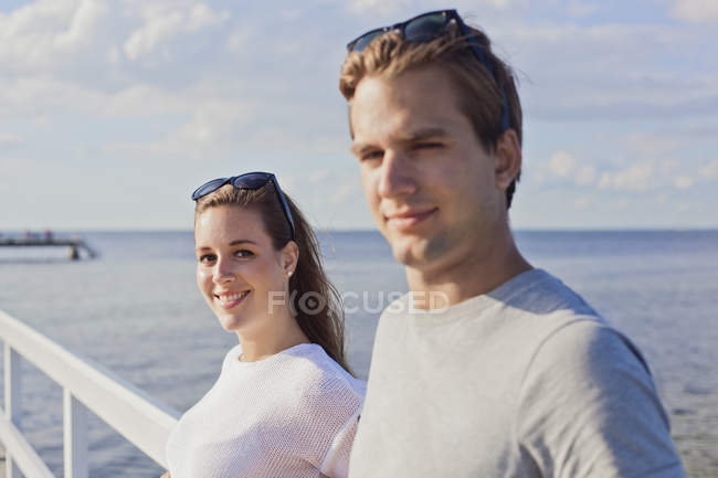 Пара стоїть на перехресті пірсу над морем — стокове фото