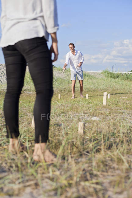 Man playing kubb with female — Stock Photo