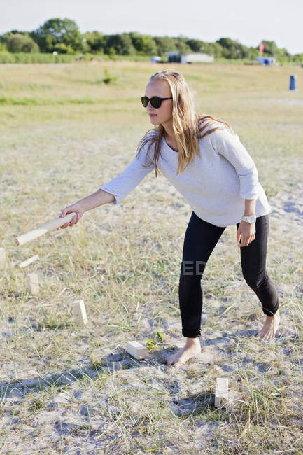 Jovem mulher jogar kubb — Fotografia de Stock