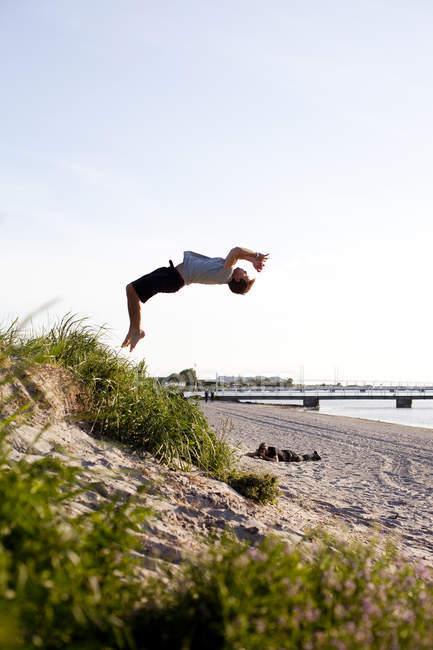 Young man doing back flip — Stock Photo