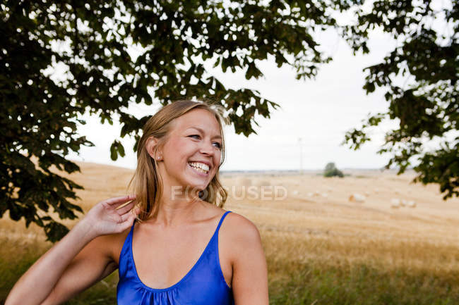 Frau schaut weg, während sie auf Feld steht — Stockfoto