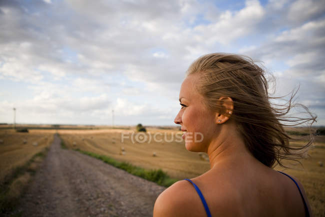 Donna che cammina su strada sterrata contro il cielo — Foto stock