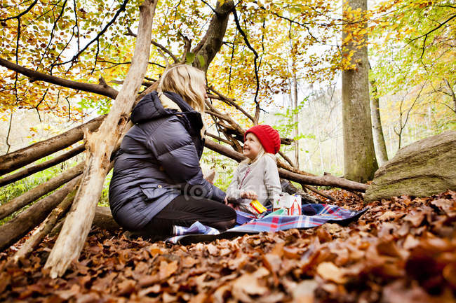Дівчина дивиться на матір, насолоджуючись пікніку — стокове фото