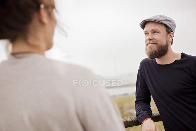 Hombre de pie con la mujer en la terraza del edificio - foto de stock