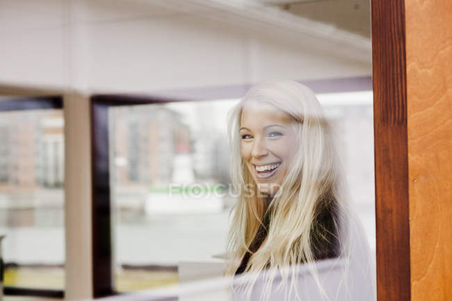 Mulher no escritório criativo visto através da janela — Fotografia de Stock