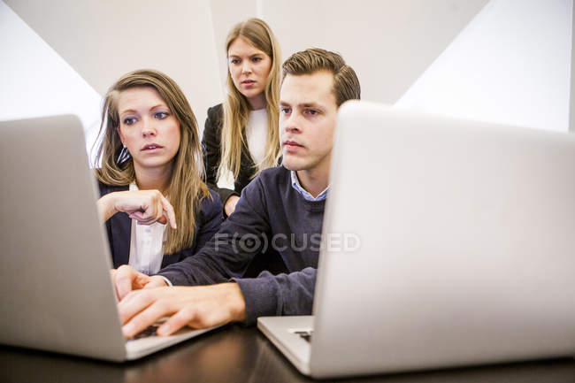 Jovens empresários usando laptop — Fotografia de Stock