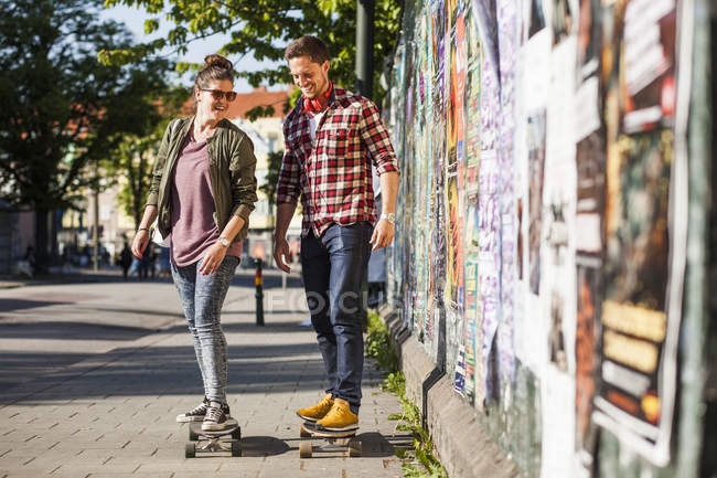 Happy couple skateboarding — Stock Photo