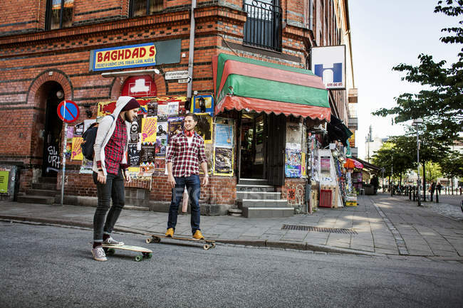 Amigos varones skateboarding - foto de stock