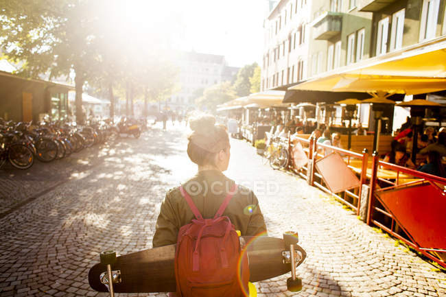 Вид сзади женщины со скейтбордом — стоковое фото