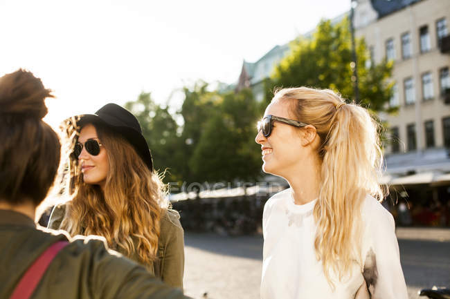 Happy woman standing with friends — Stock Photo