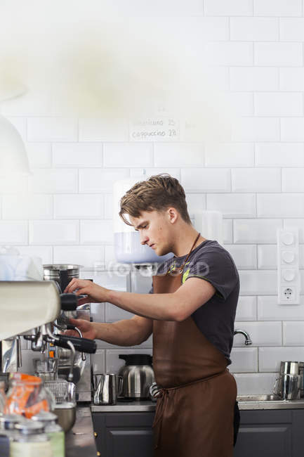 Junger Barista bereitet Kaffee zu — Stockfoto