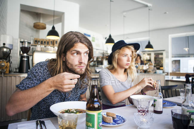 Friends having food at table in restaurant — Stock Photo