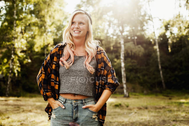 Woman looking away while standing at forest — Stock Photo