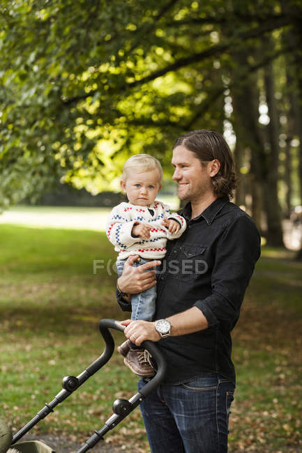 Bambina portata dal padre nel parco — Foto stock