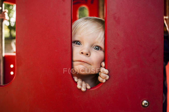Chico mirando a través de tren en miniatura - foto de stock