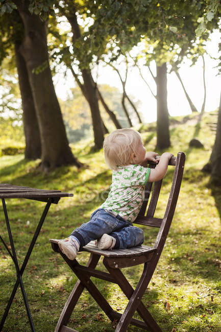 Niedlicher kleiner Junge sitzt auf Stuhl — Stockfoto