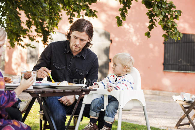 Père et bébé fille assis à la table — Photo de stock