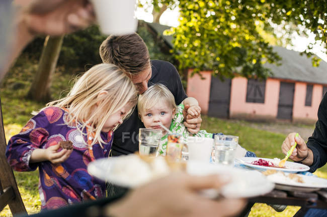 Familia feliz sentada a la mesa - foto de stock