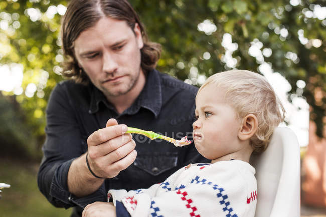 Vater füttert kleines Mädchen — Stockfoto