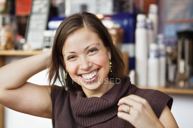 Woman with hand behind head at cafe — Stock Photo
